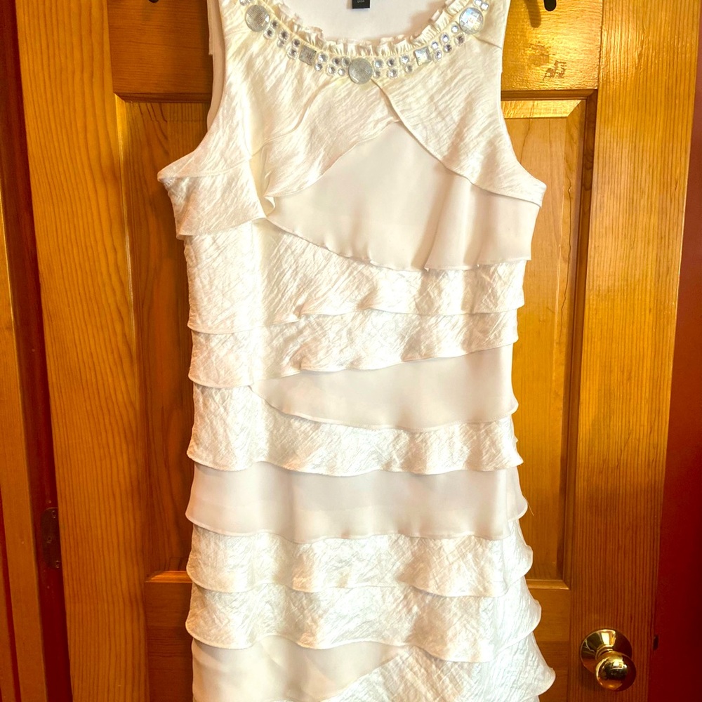 Cream color above the knee flounce dress with gems at neckline. Size 16
